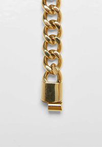 Guld kæde med store, ovale led og en blank hængelås i enden. Glat tekstur, reflekterende overflade, industrielt design.