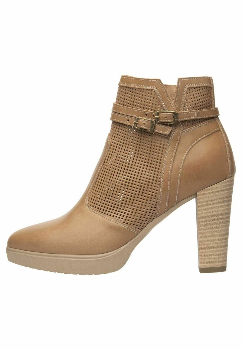 Bottine tan avec panneaux en cuir perforé, une sangle à boucle et un talon en bloc texturé. Présente une pointe lisse et une semelle en caoutchouc plate.