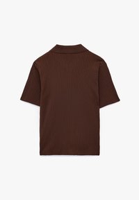 Brun ribbet kortærmet polo skjorte med klassisk krave og en tætsiddende pasform. Blød tekstur med en glat finish og minimale syninger.