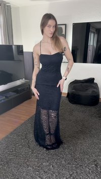 Vestido maxi em renda preta com silhueta ajustada, alças finas e painéis de renda translúcida na metade inferior. Textura suave.