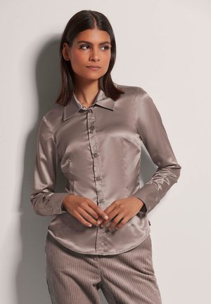 Satijnen overhemd met knoopsluiting in licht taupe, met kraag, lange mouwen en een slanke pasvorm. Het heeft een knoopmanchet en een gladde textuur.