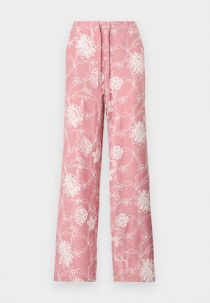 Pantalon ample rose avec broderie florale blanche et taille à cordon, étalé à plat sur un fond neutre.