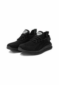 Zapatillas deportivas negras con parte superior de malla, suelas texturizadas, cordones elásticos y un collar acolchado. Presentan un detalle plateado de marca en la lengüeta.