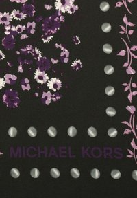 Czarna tkanina z fioletowym i białym wzorem kwiatowym, z centralnie umieszczonym logo "MICHAEL KORS" oraz dekoracyjnymi srebrnymi kropkami wzdłuż dolnej krawędzi.
