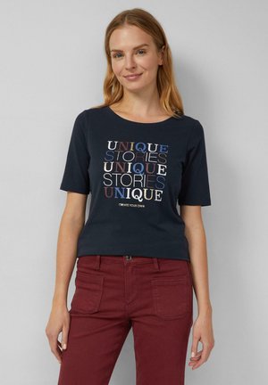 Marineblaues T-Shirt mit kurzen Ärmeln und Rundhalsausschnitt, das mehrfarbigen Text zeigt: "EINZIGARTIGE GESCHICHTEN, ERFÜLLE DEINE EIGENEN." Weicher Stoff, lockere Passform.