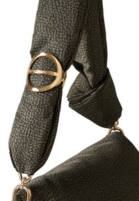 Sangle de sac à main en tissu à motif vert avec un anneau en métal doré et un clip pour fixation, avec une section nouée pour ajouter de la texture.