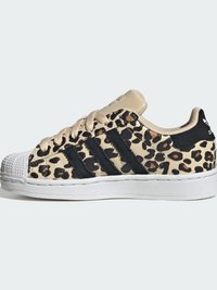 Χαμηλό sneaker με μπεζ και μαύρο σχέδιο λεοπάρδαλης, μαύρες ρίγες Adidas, μπεζ κορδόνια, λευκή λαστιχένια προπέλα και λευκή σόλα.