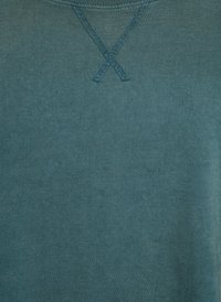 Felpa in teal, realizzata in morbido tessuto. Presenta un dettagliato punto croce sul colletto e un orlo a coste per una texture accattivante.