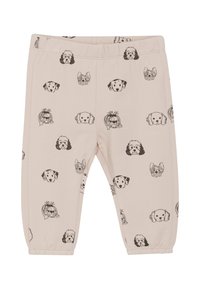 Jasno beżowe legginsy z powtarzającym się wzorem czarnych głów psów. Wykonane z miękkiego materiału, z elastycznym pasem w talii i zwężającymi się nogawkami.