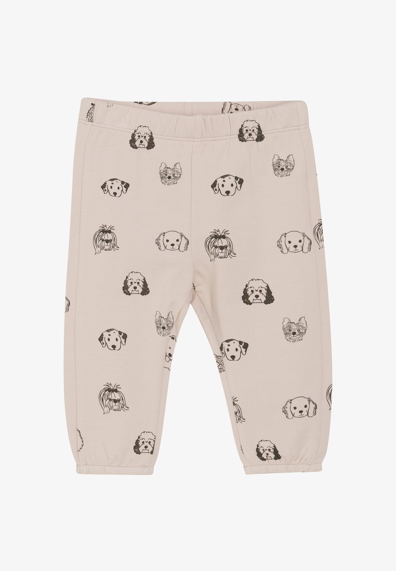 Jasno beżowe legginsy z powtarzającym się wzorem czarnych głów psów. Wykonane z miękkiego materiału, z elastycznym pasem w talii i zwężającymi się nogawkami.