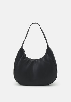 Sac hobo en cuir noir avec une forme incurvée, fermeture éclair et une seule sangle pour l'épaule. Présente un logo minimaliste à l'avant.