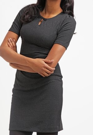 Czarna sukienka z krótkimi rękawami, z detalem dekoltu w kształcie otworu oraz białymi kropeczkami. Dopasowany krój, lekka tkanina i gładka faktura.