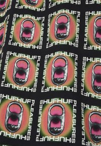 Tessuto nero con un design grafico ripetuto di loghi colorati con le parole "HUF" e "PLEASURES", centrato attorno a un'immagine stilizzata di una lattina.