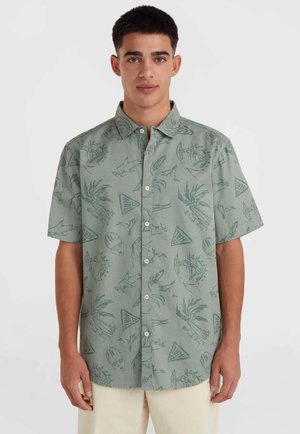 Korte mouwen button-up shirt in lichtgroene stof met een patroon van vissen, palmbladeren en driehoeken in donkerdere groentinten.