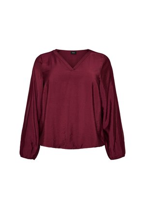 Blouse en satin à manches longues couleur bordeaux profond, avec un col en V et des poignets légèrement froncés aux manches.