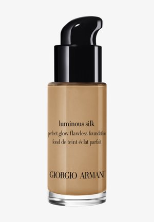 Glassflaske med Giorgio Armani Luminous Silk foundation, lys brun nyanse, med svart pumpehette og svart tekstetikett som beskriver produktnavn og beskrivelse.