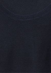 Tessuto di maglia blu scuro con una superficie testurizzata, caratterizzato da un collo rotondo. Tessitura uniforme con lievi variazioni nella densità dei punti.