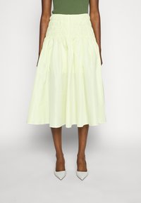 Jupe jaune clair, longueur genoux, avec une taille smockée, fabriquée dans un matériau léger, présentant un design ample et fluide.