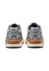 Sneaker in suede grigio con dettagli in pelle beige, dotate di suola imbottita, finiture testurizzate e embellimenti con logo sul tallone.