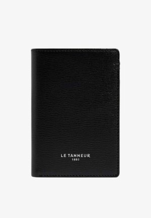 Schwarze, texturierte Lederbrieftasche mit weißem "LE TANNEUR 1893" Logo, mittig vorne auf weißem Hintergrund.