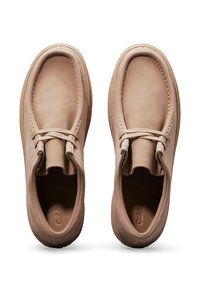 Scarpe in pelle marrone con finitura liscia, dotate di punta rotonda, lacci sottili e suola imbottita. Il design è minimalista e a taglio basso.