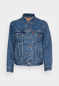 Tummaa sinistä denim-takkia, jossa on klassinen kaulus, etupuolen läpälliset taskut, nappisuljenta ja hienovarainen haalistunut rakenne.