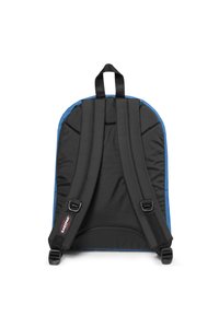 Mochila de tela negra con acentos azules. Espalda acolchada y correas ajustables. Elementos destacados incluyen detalles de costura y un lazo para colgar en la parte superior.