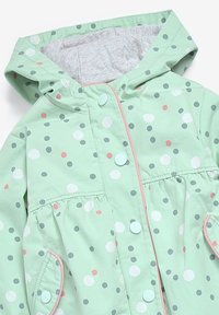 Giacca da pioggia verde menta con cappuccio, decorata con pois multicolori, bottoni a pressione e dettagli rosa; vita arricciata e tasche laterali.