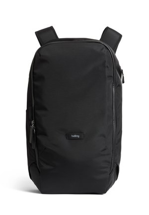 Sac à dos noir en tissu durable, doté de bretelles rembourrées, d'un compartiment principal zippé et d'une poche avant avec un logo.