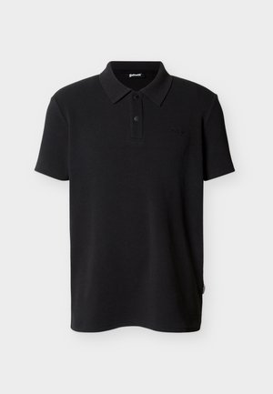 Polo nera a maniche corte con due bottoni, piccolo logo ricamato sul petto e una piccola etichetta di stoffa sulla cucitura laterale.