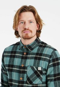 Flanellen overhemd in teal met een zwart-wit ruitpatroon, voorzien van een button-down kraag, houten knopen en een borstzak met een logo patch.