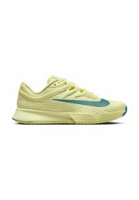 Zapatilla deportiva de color amarillo lima con parte superior texturizada, acentos verdes, diseño aerodinámico y suela con amortiguación visible. Presenta un logo tipo swoosh.