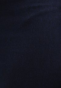Dark blue denim fabric with a smooth texture, featuring a subtle weave pattern and slight variations in color throughout.