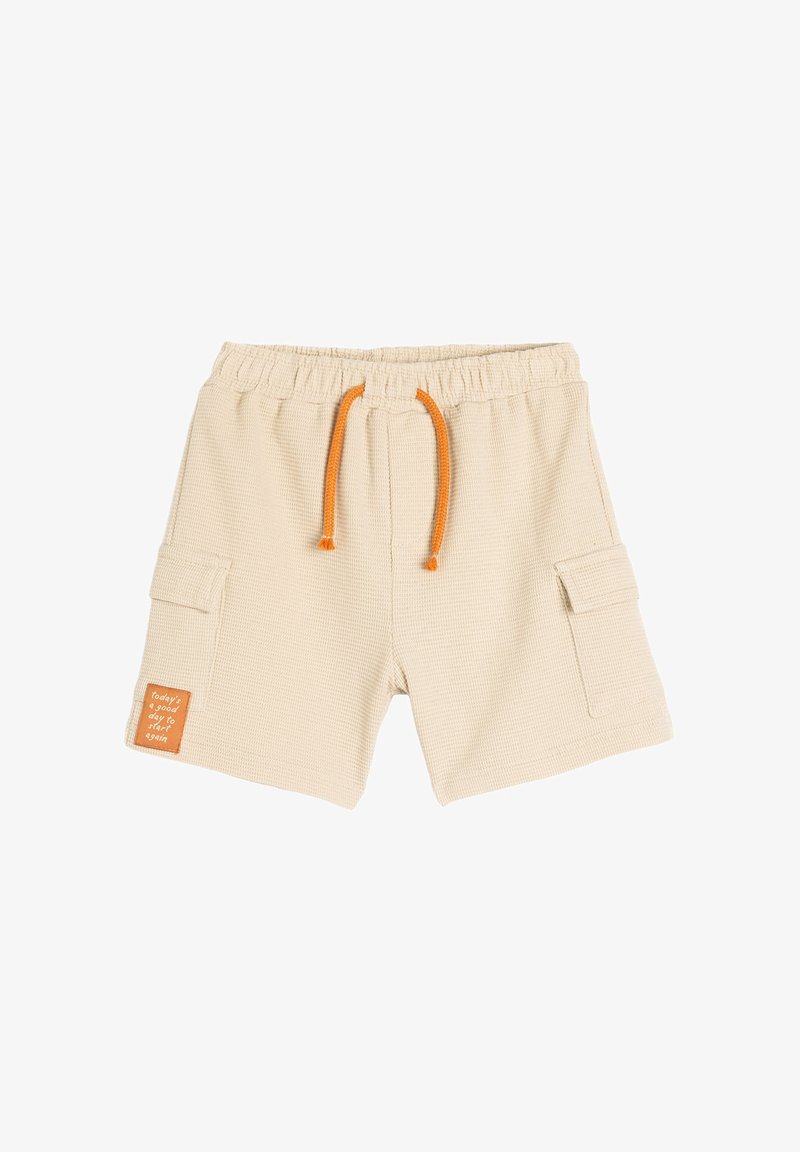 Beige teksturerede shorts med elastisk talje, orange snøre, sidelommer og et patch der siger "i dag er en god dag til at starte igen."