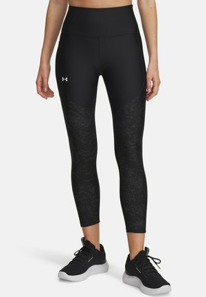 Black athletic leggings with a high waistband, featuring a textured pattern on the sides, paired with black athletic shoes.