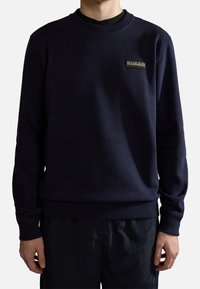 Felpa blu navy con scollo rotondo, polsini e orlo a coste. Presenta una piccola toppa con logo ricamato sul petto. Tessuto morbido, vestibilità casual.