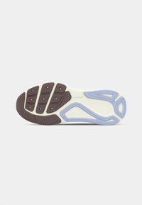 Σόλα αθλητικού παπουτσιού με εκρού βάση, καφέ πέλμα στο μπροστινό μέρος και ανοιχτό μπλε λαστιχένιες λεπτομέρειες στη φτέρνα και στη μέση του ποδιού πάνω σε γκρι φόντο.