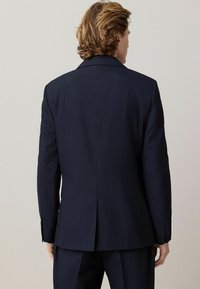 Marineblauer Streifenanzugjacke, strukturiertes Design, Reverskragen, doppelte Schlitze hinten und geknöpfte Manschetten. Glatter Stoff, taillierte Passform.