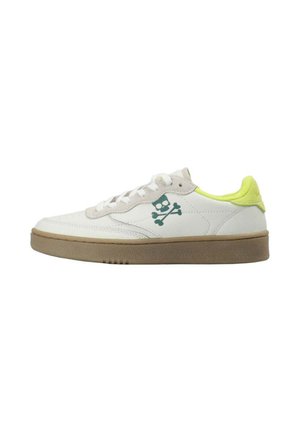 Zapatilla blanca con suela beige, cuello del talón amarillo neón y logo verde de calavera con huesos cruzados en el lateral.