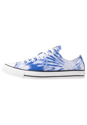 Niski sneaker z niebiesko-białym płótnem farbowanym w stylu tie-dye, biała gumowa podeszwa z czarnym paskiem, białe sznurówki i metalowe przekładki, widoczny z boku.
