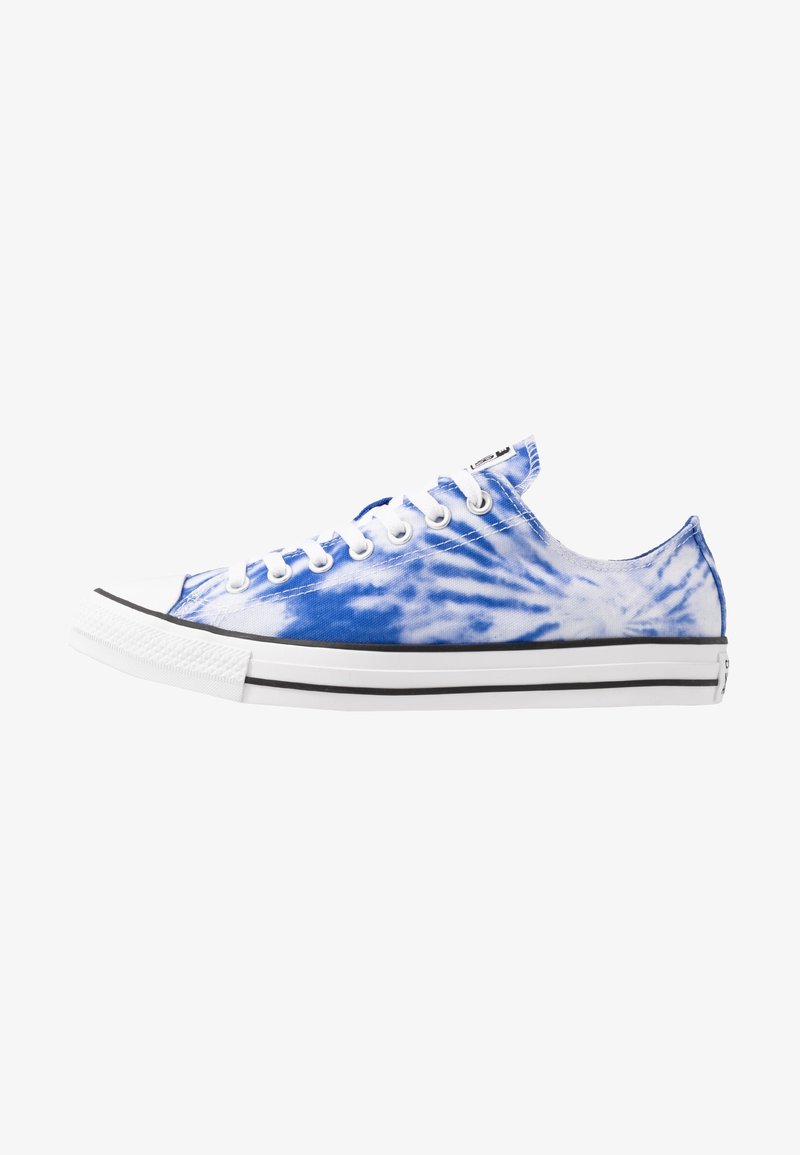 Baskets basses en toile tie-dye bleue et blanche, semelle en caoutchouc blanc avec bande noire, lacets blancs et œillets en métal, vues de côté.