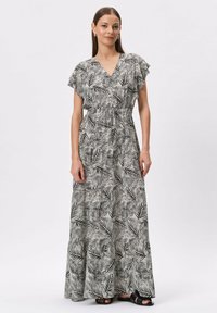 Maxi sukienka w czarno-białym kolorze z wzorem liści palmowych, dekolt w kształcie litery V, krótkie falbaniaste rękawy, ściągnięta w talii, z lejącą się spódnicą. Gładka tekstura materiału.