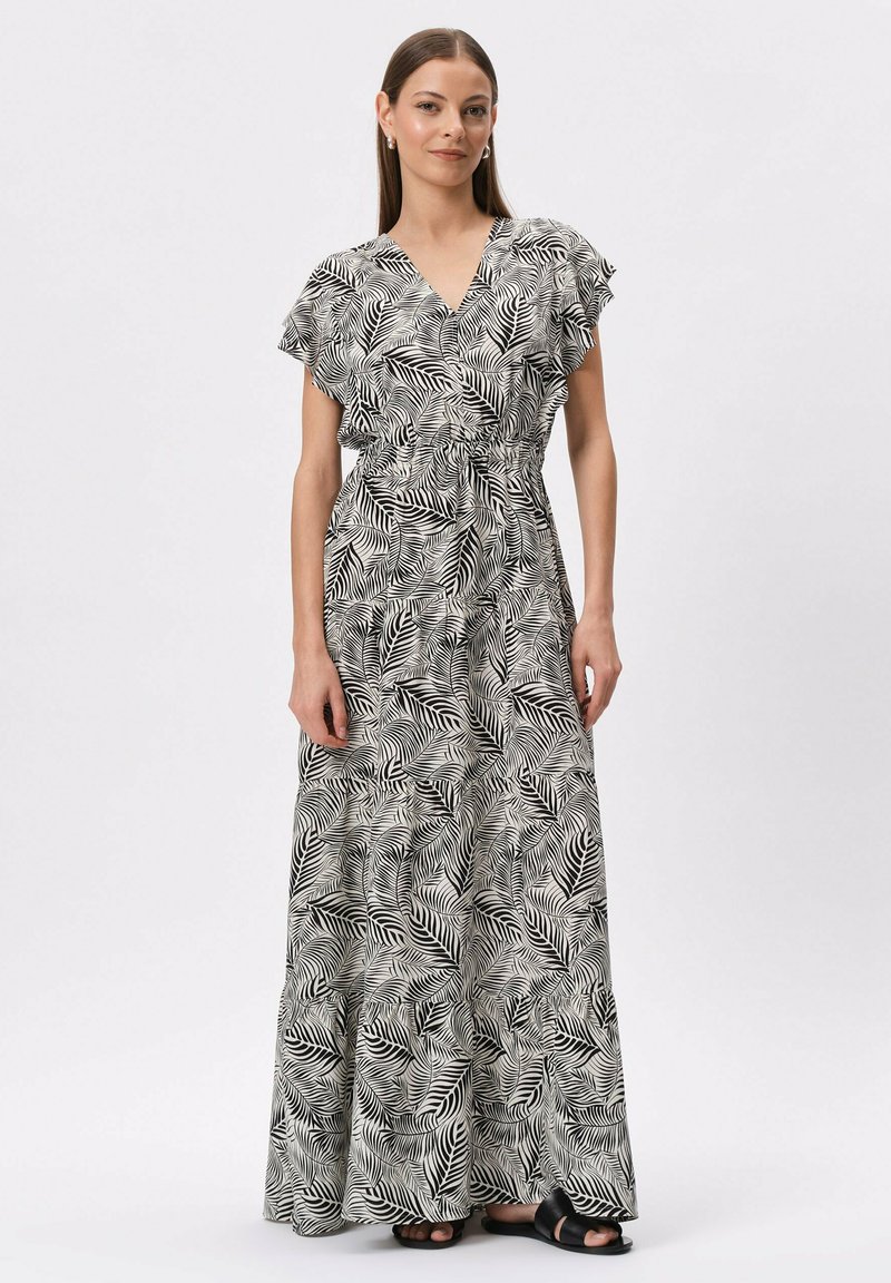 Maxi sukienka w czarno-białym kolorze z wzorem liści palmowych, dekolt w kształcie litery V, krótkie falbaniaste rękawy, ściągnięta w talii, z lejącą się spódnicą. Gładka tekstura materiału.