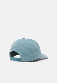 Light blue corduroy cap with a curved brim, featuring a textured surface, adjustable snapback closure, and ventilation eyelets.