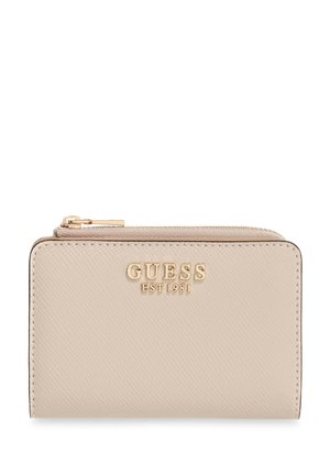 Portefeuille beige Guess avec fermeture éclair dorée et logo Guess avec "EST 1981" sur le devant, surface en cuir texturé.