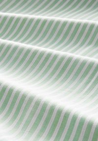 Green and white striped fabric with a soft texture, showing alternating stripes of light green and white across a smooth surface.