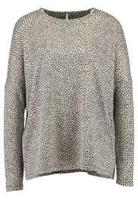 Langarm-Pullover im Creme- und Schwarzsternmuster. Mit Rundhalsausschnitt und lockerer Passform, überschnittenen Schultern und seitlichem Schlitzsaum.