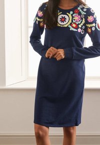 Abito navy a maniche lunghe, con ricami floreali colorati attorno al collo. Tessuto morbido con una vestibilità morbida e design alla lunghezza del ginocchio.