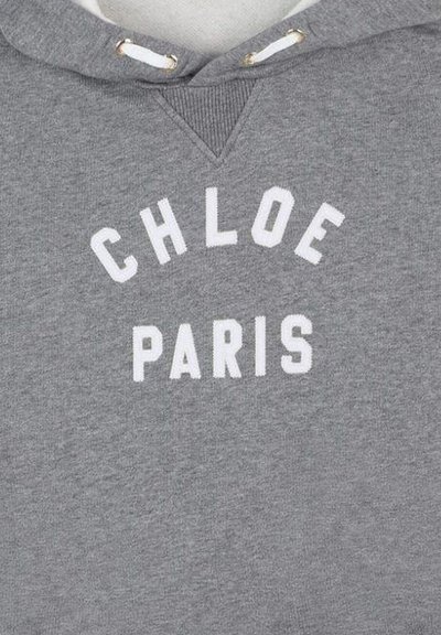 Felpa grigia con cordini bianchi che presenta lettere bianche in blocco a forma di "CHLOE PARIS" sul petto.