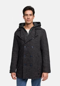 Abrigo peacoat de mezcla de lana oscura con textura de espiga, botones de doble pecho y capucha desmontable sobre un suéter más claro debajo.